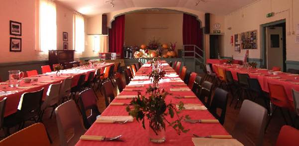 Long table with red tablecloths and flowers

AI-generated content may be incorrect.