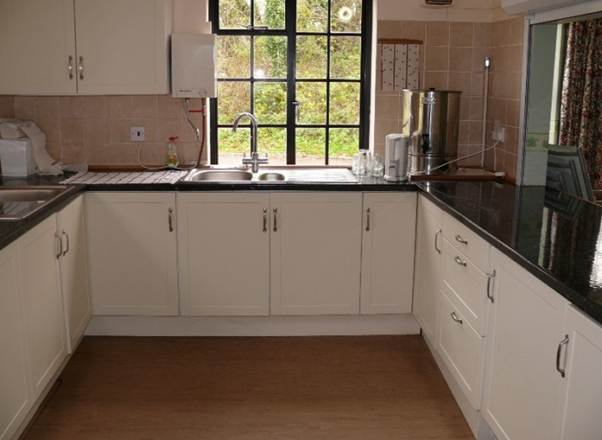 A kitchen with white cabinets and black counter tops

AI-generated content may be incorrect.